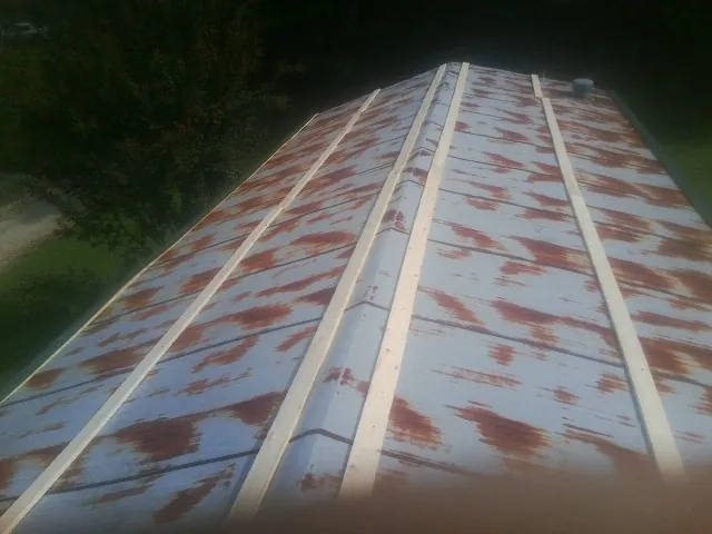Rusted metal roof panels with new wood purlins before replacement — Storm Damage Roof Repair in Gleason by Roofing Brothers