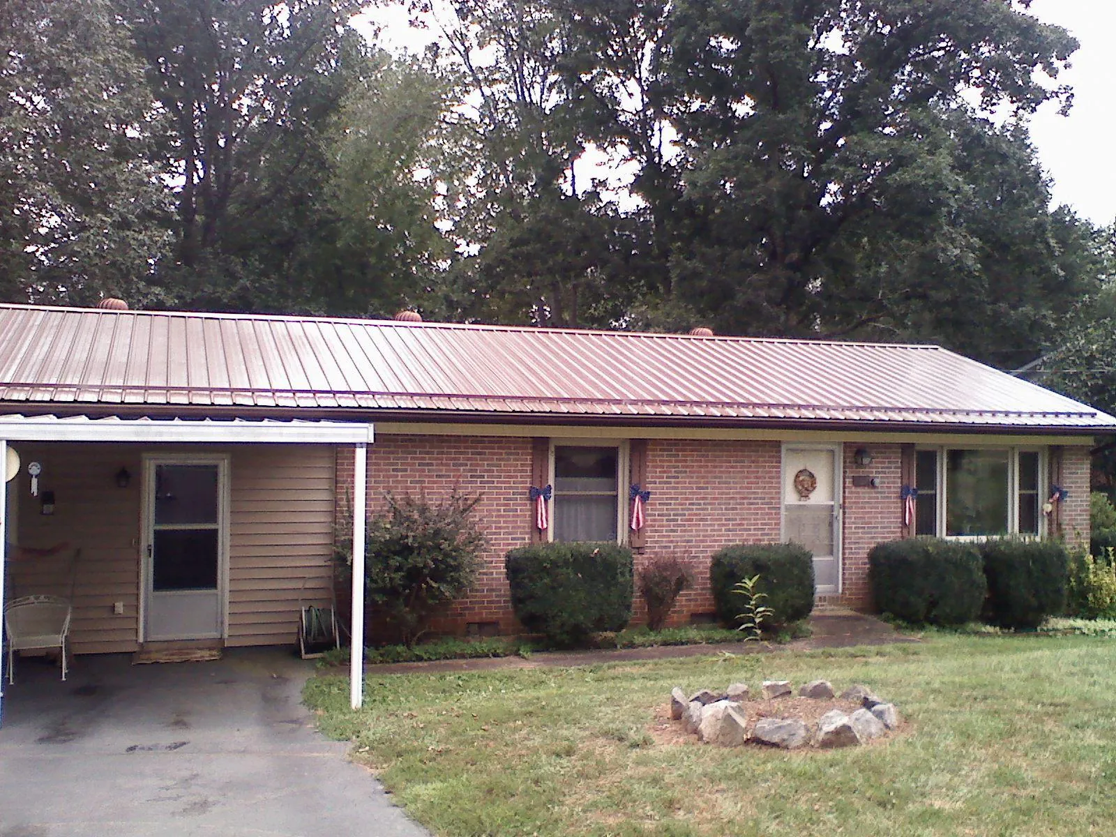 Bronze metal roof and carport on a brick ranch home — Roof Repair work by our crew in Gleason